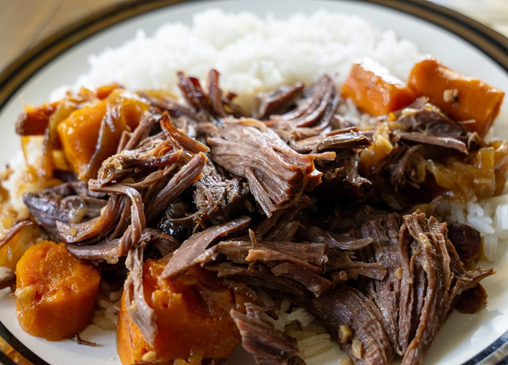 Beef shoulder roast on a plate with a side of rice